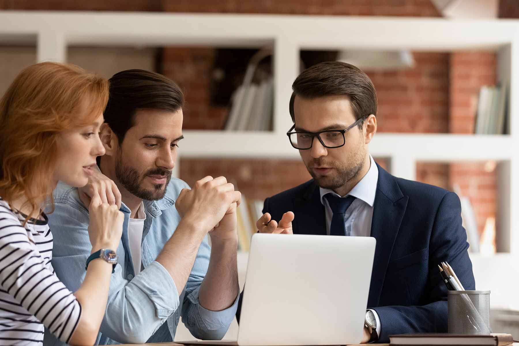 Lawyer discussing defamation lawsuit strategy to clients over a laptop Lawyer discussing defamation lawsuit strategy to clients over a laptop